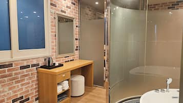 A modern bathroom with a shower, a vanity with a mirror, and a window.