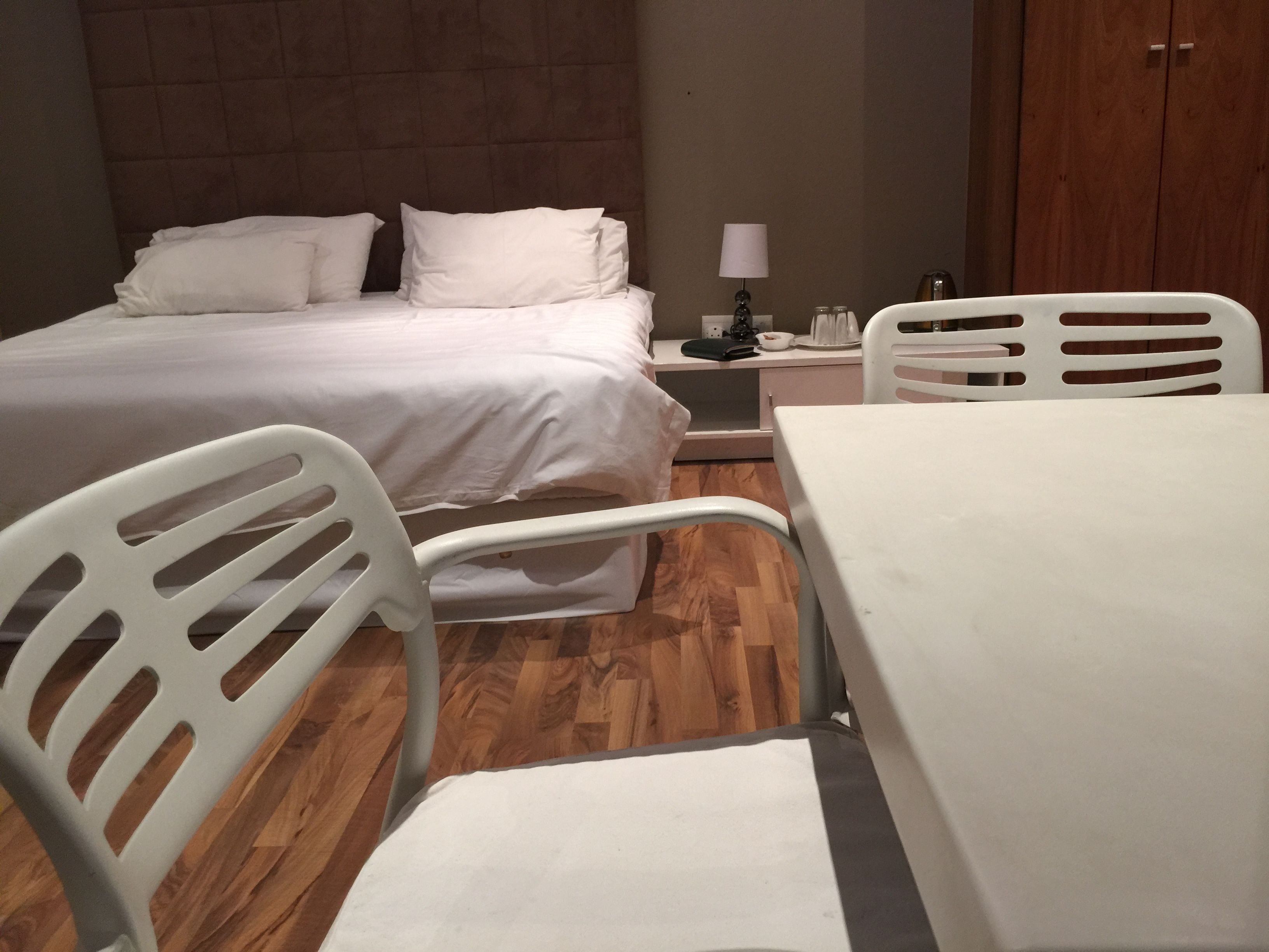 Una habitación de hotel con una cama, una mesita de noche, una mesa y dos sillas.