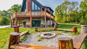 Una cabaña con terraza de madera, chimenea de piedra y pared de piedra.