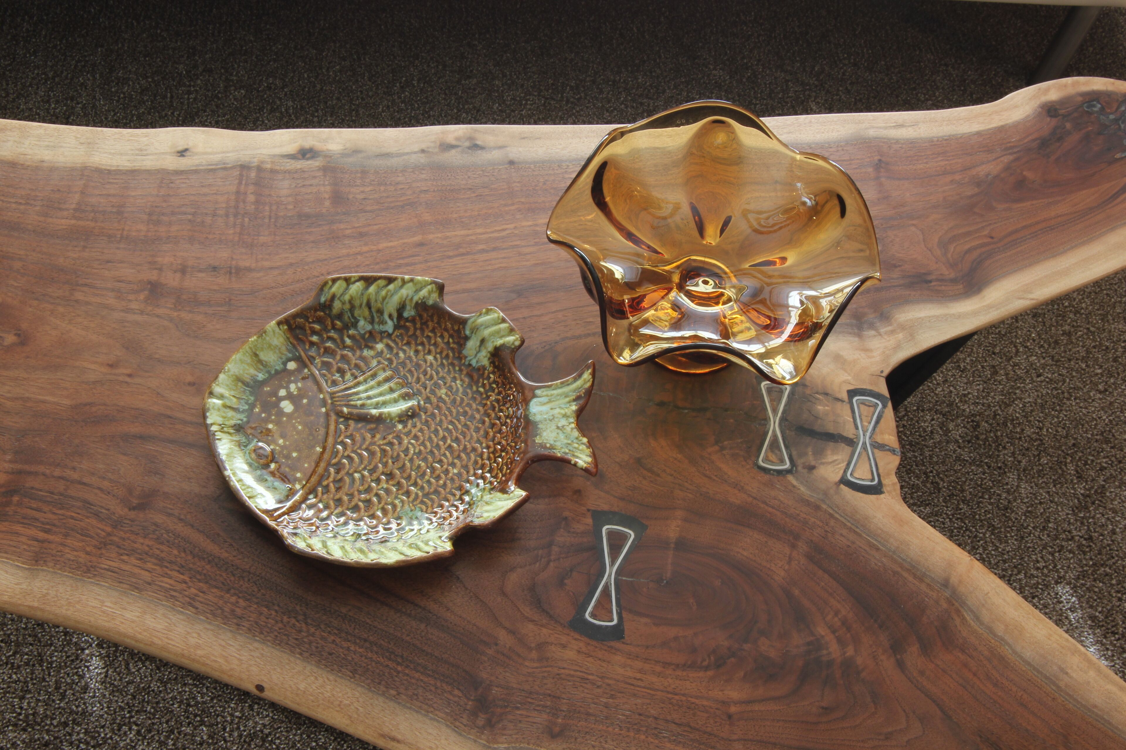 Two ceramic fish-shaped dishes on a wooden tray.