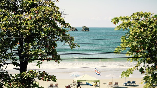 Ein Strand mit Liegestühlen, Sonnenschirmen und einem Zelt.