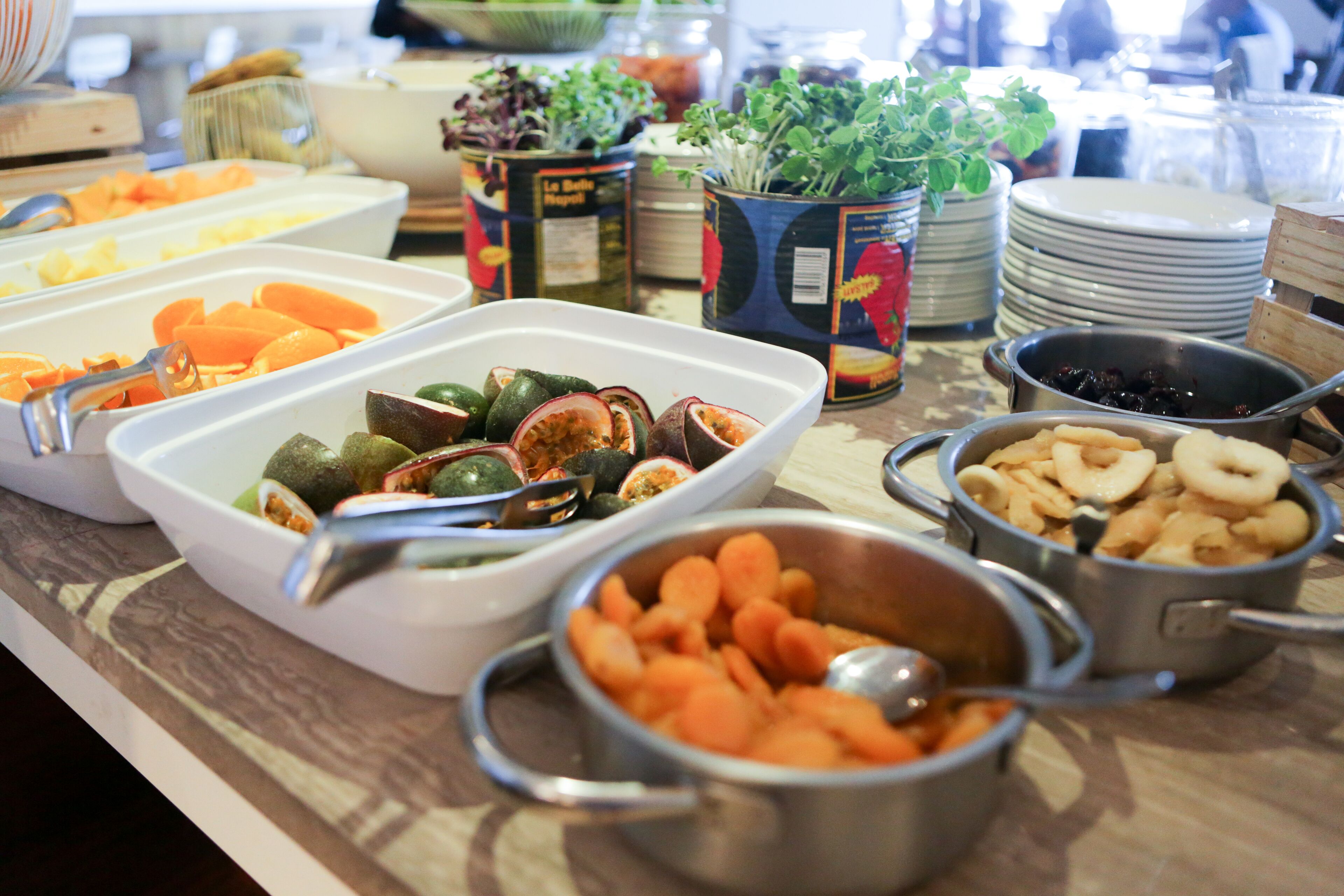 A buffet with various food items including fruits, vegetables, and nuts.