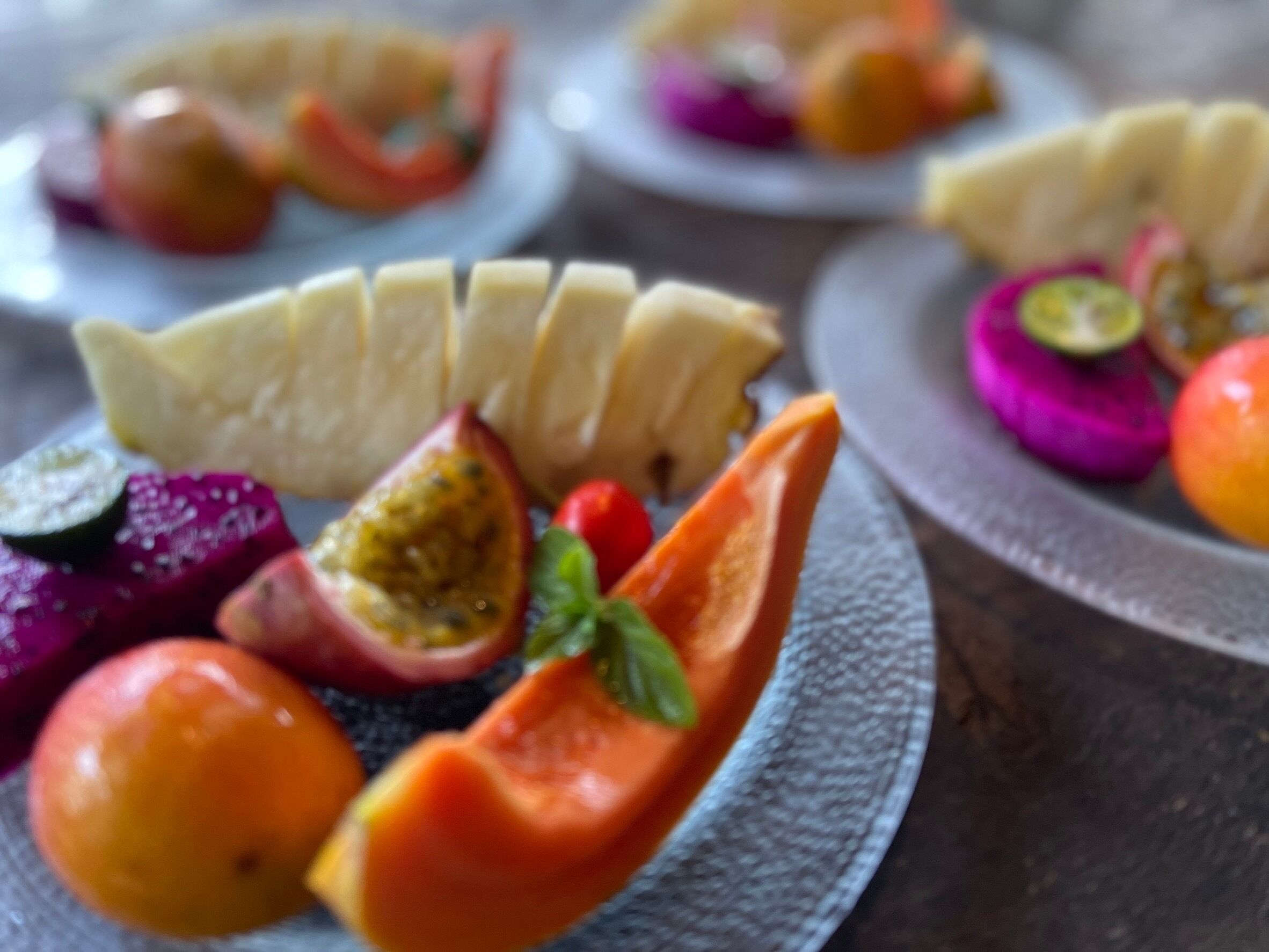 A plate with sliced bananas, figs, and a bell pepper.