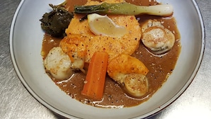A plate of food with various vegetables and a sauce.