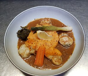 Une assiette de nourriture contenant divers légumes et une sauce.