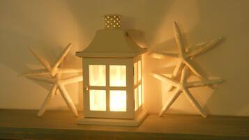 A white lantern with a hexagonal window design, placed on a wooden surface.