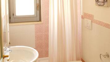 A bathroom with a bathtub, toilet, and two sinks.