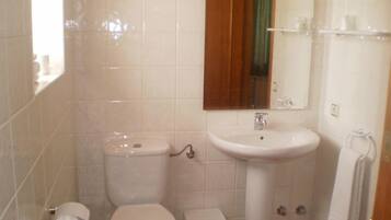 Un baño pequeño con inodoro, lavabo y espejo.