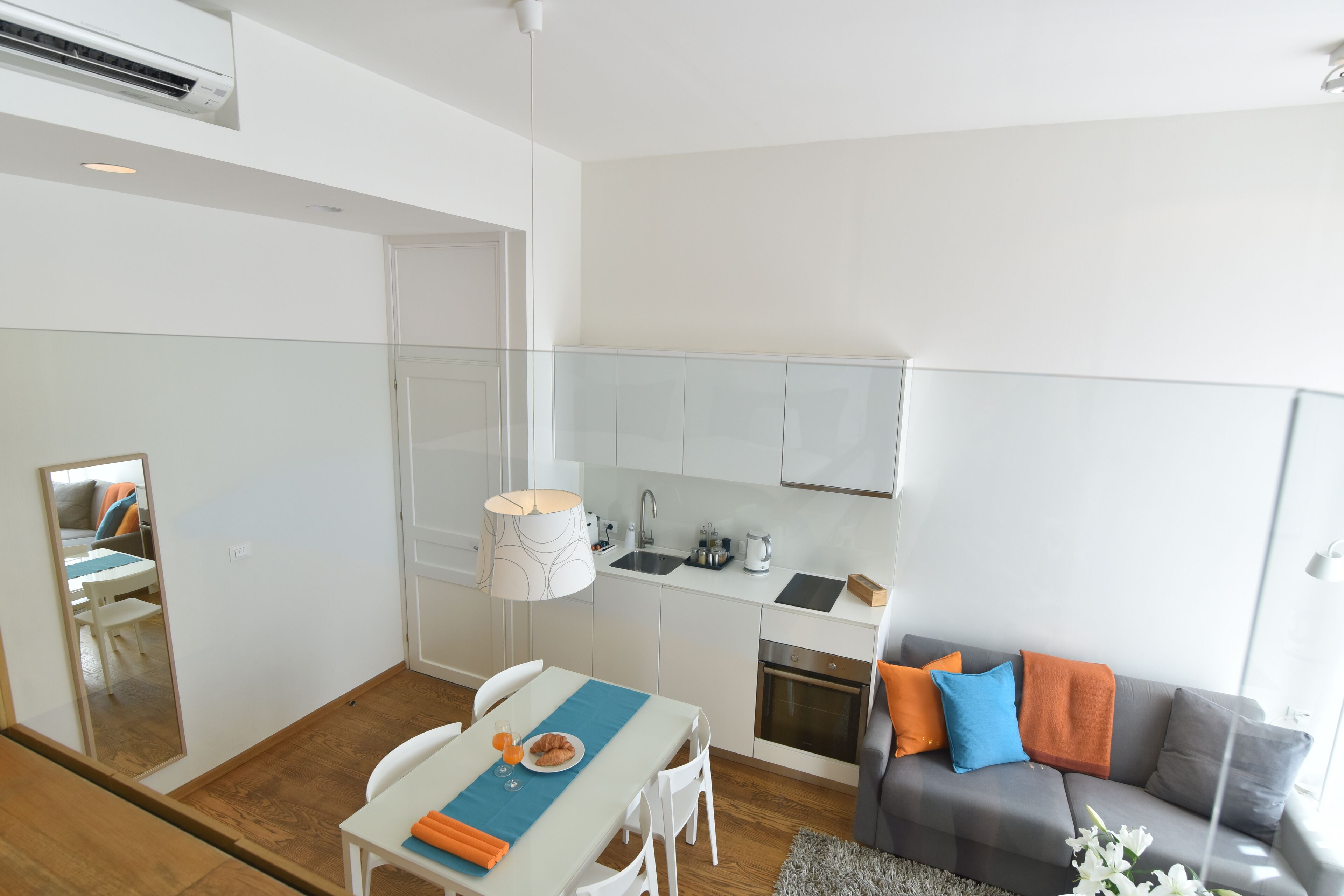 A modern apartment with a dining area, kitchenette, and living space.