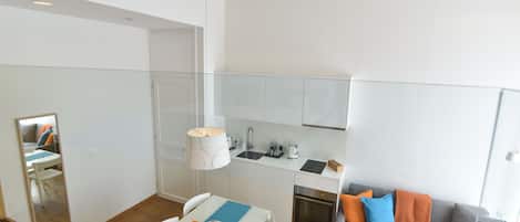A modern apartment with a dining area, kitchenette, and living space.