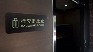 Sinal indicando um depósito de bagagens, com um ícone de mala e texto em chinês e inglês.