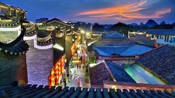 A traditional Chinese architectural complex with tiered roofs and lanterns, featuring a central walkway and surrounding buildings.
