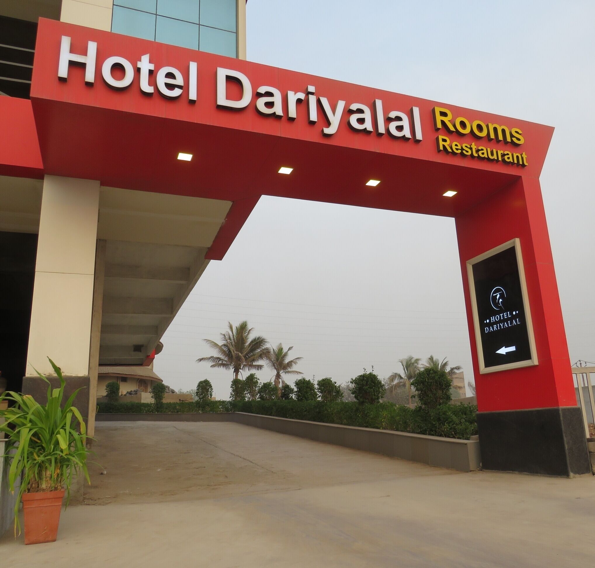 The entrance to Hotel Dariyalal with a red archway and a sign indicating Rooms and Restaurant.