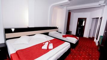 A hotel room with two beds, a red carpet, and a modern design.