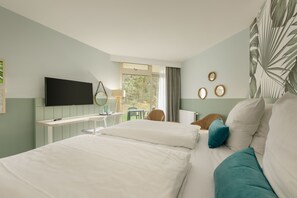 A hotel room with two beds, a desk, a TV, and a window with curtains. - Hotel Bispinger Heide by Center Parcs (Bispingen)