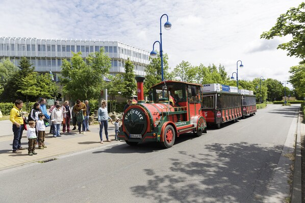 A vintage steam train with passengers on the platform.