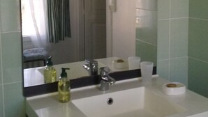Un baño con lavamanos blanco, un espejo y una cortina de ducha.