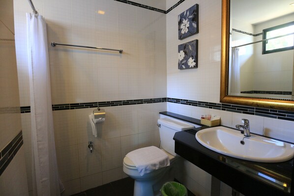 A bathroom with a toilet, sink, and shower curtain. - At Home at Chiang Mai (Chiang Mai)