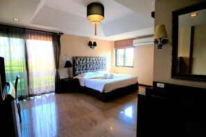 A hotel room with a large bed, a ceiling lamp, a wall-mounted TV, and a large mirror. - At Home at Chiang Mai (Chiang Mai)