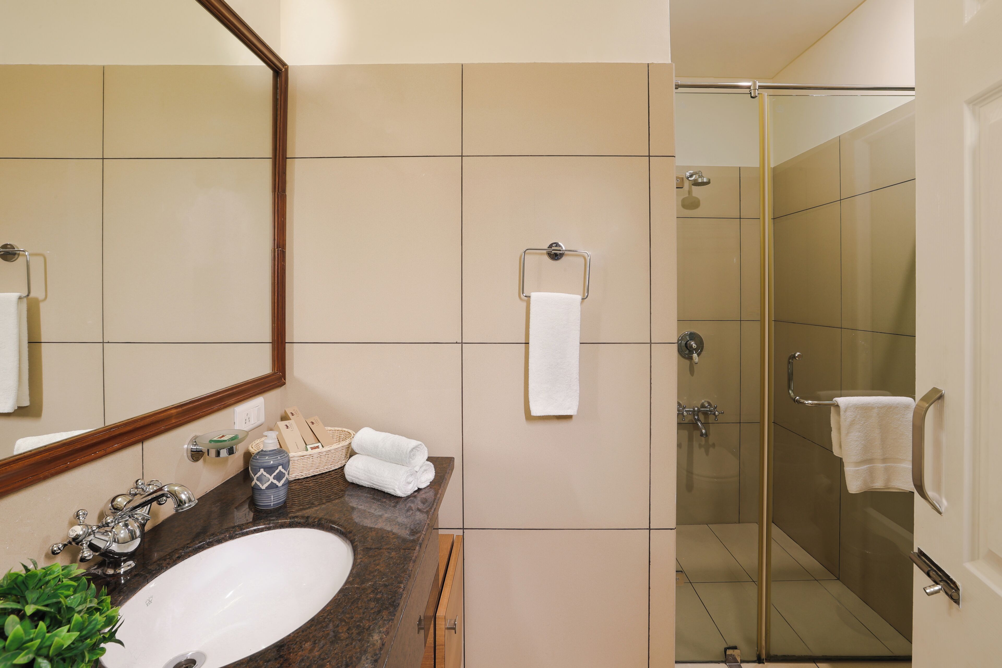 A bathroom with a sink, mirror, and a shower area.