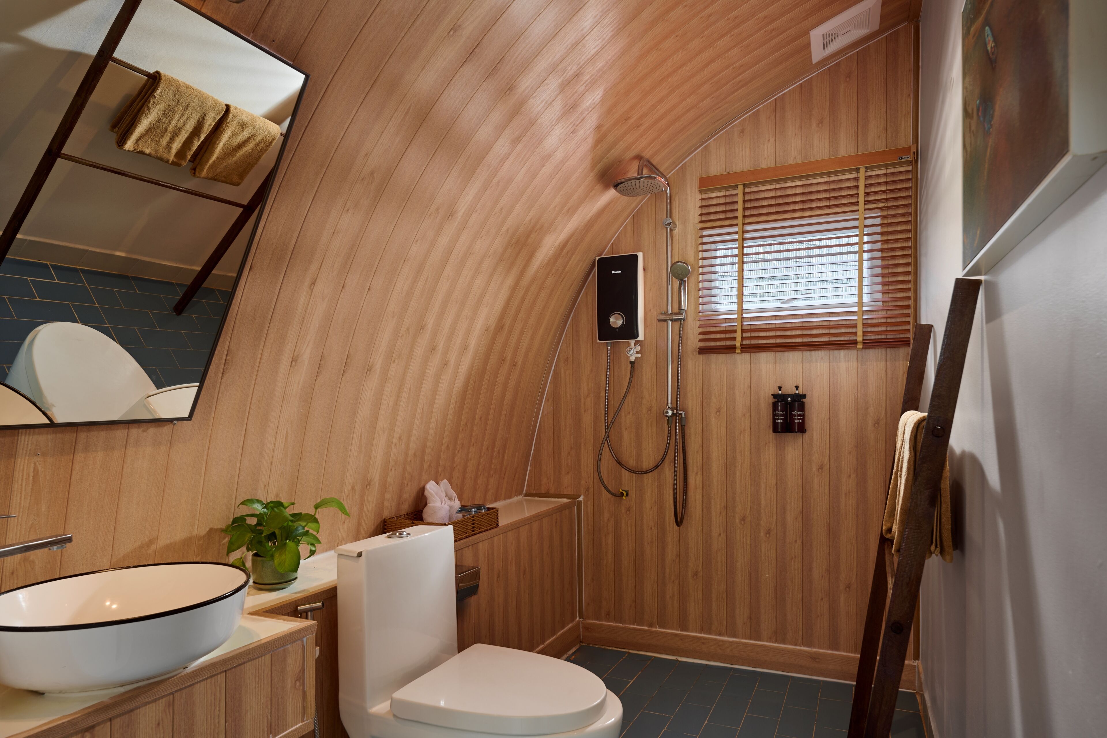 A wooden-paneled bathroom with a white sink, toilet, and shower.