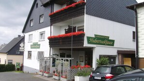 Un bâtiment à deux étages sur lequel on peut lire l’inscription « Landgasthof Hubertuskause ».