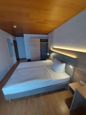 Un dormitorio moderno con cama, mesita de noche y armario.