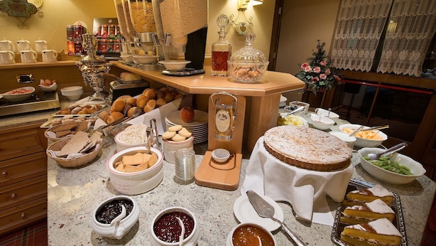 A buffet with various food items, including pastries, fruits, and condiments. - cervo (Livigno)