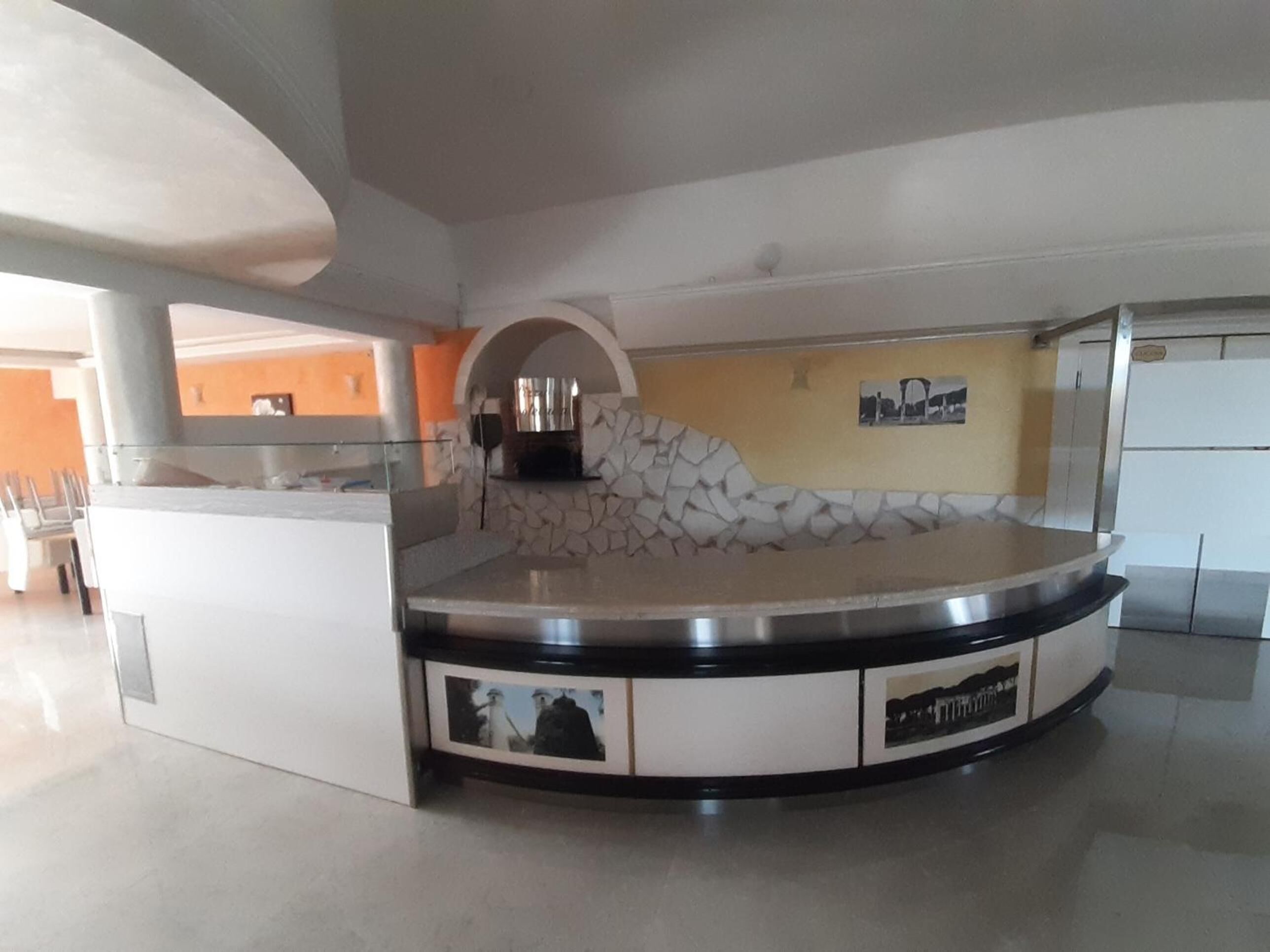 A circular bar area with a stone wall backdrop, a built-in grill, and a seating arrangement.