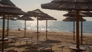 A beach with multiple thatched umbrellas and lounge chairs. - Klaton Beach Hotel (Formia)