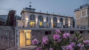 A modern building with a stone facade, multiple balconies, and a gated entrance. - Klaton Beach Hotel (Formia)