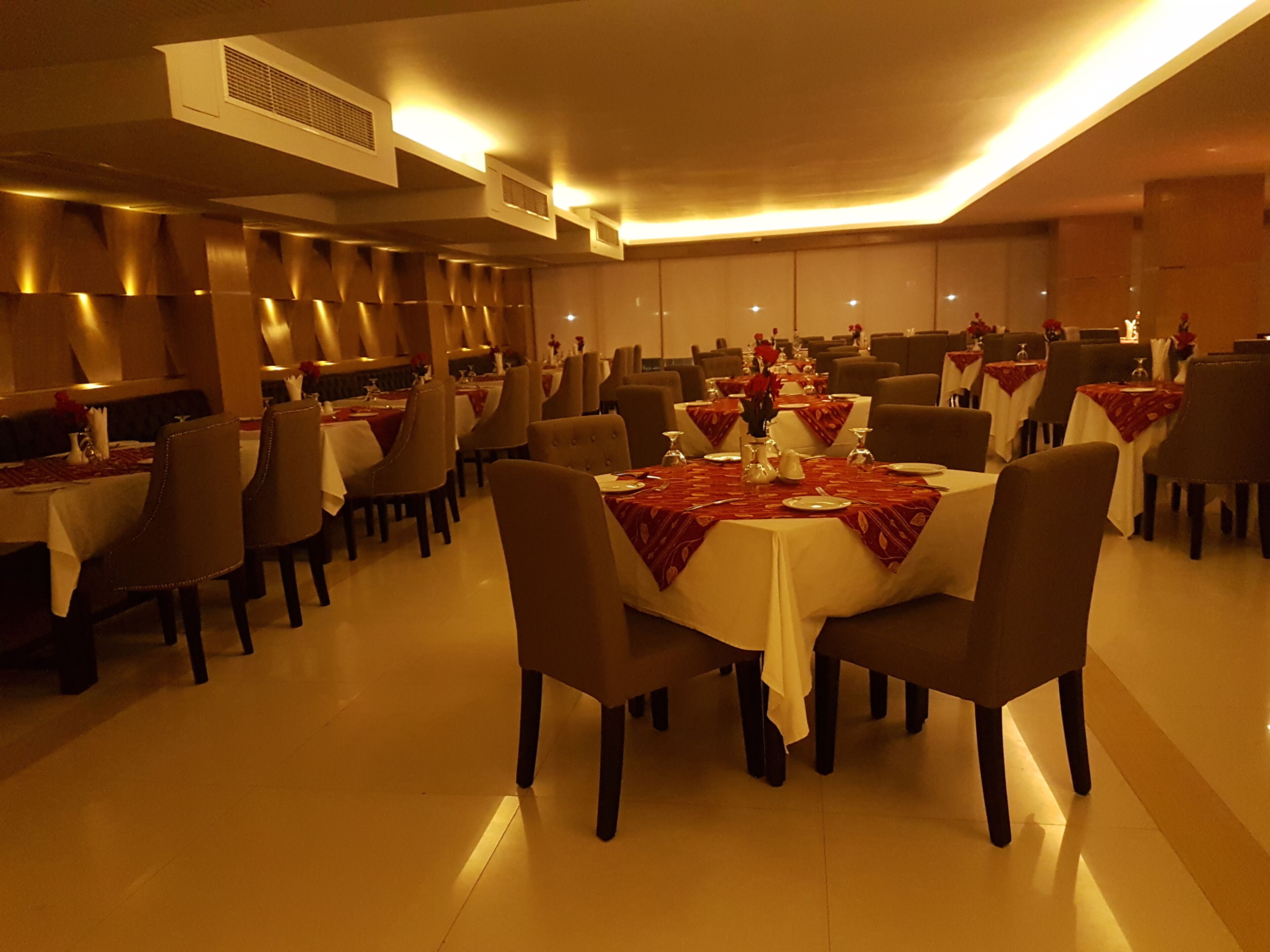 A restaurant with round tables, chairs, and a warm ambiance.