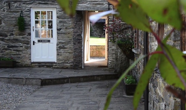 A stone building with a white door labeled "Y SCUBOR".