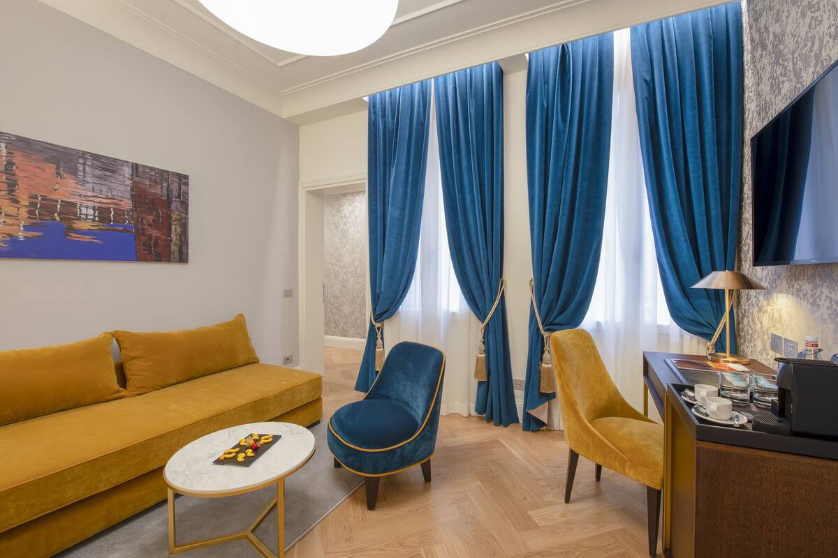 Una sala de estar moderna con un sofá, dos sillones, una mesa de centro y un televisor.