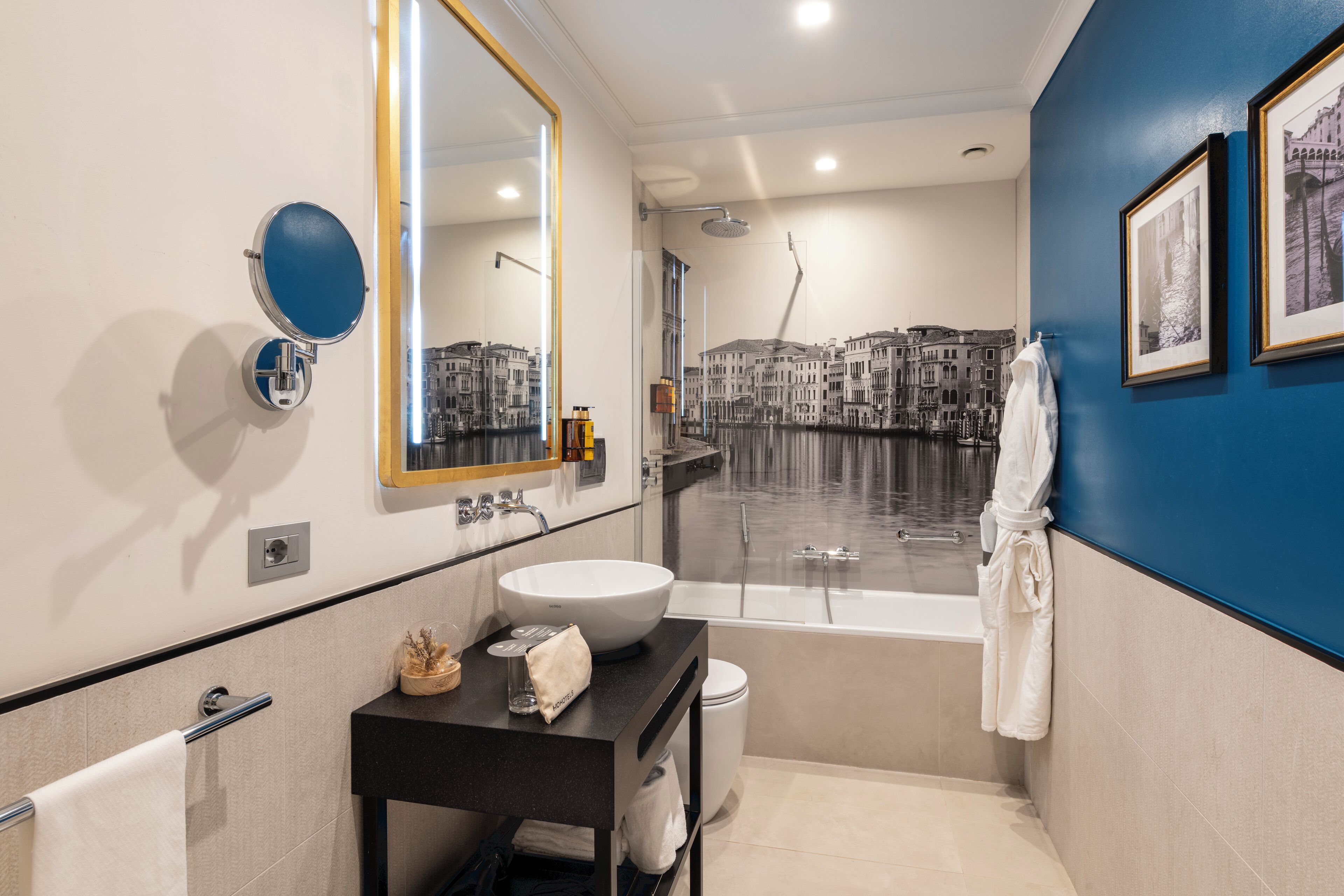 A modern bathroom with a large mirror, a round sink, a bathtub, and a shower.