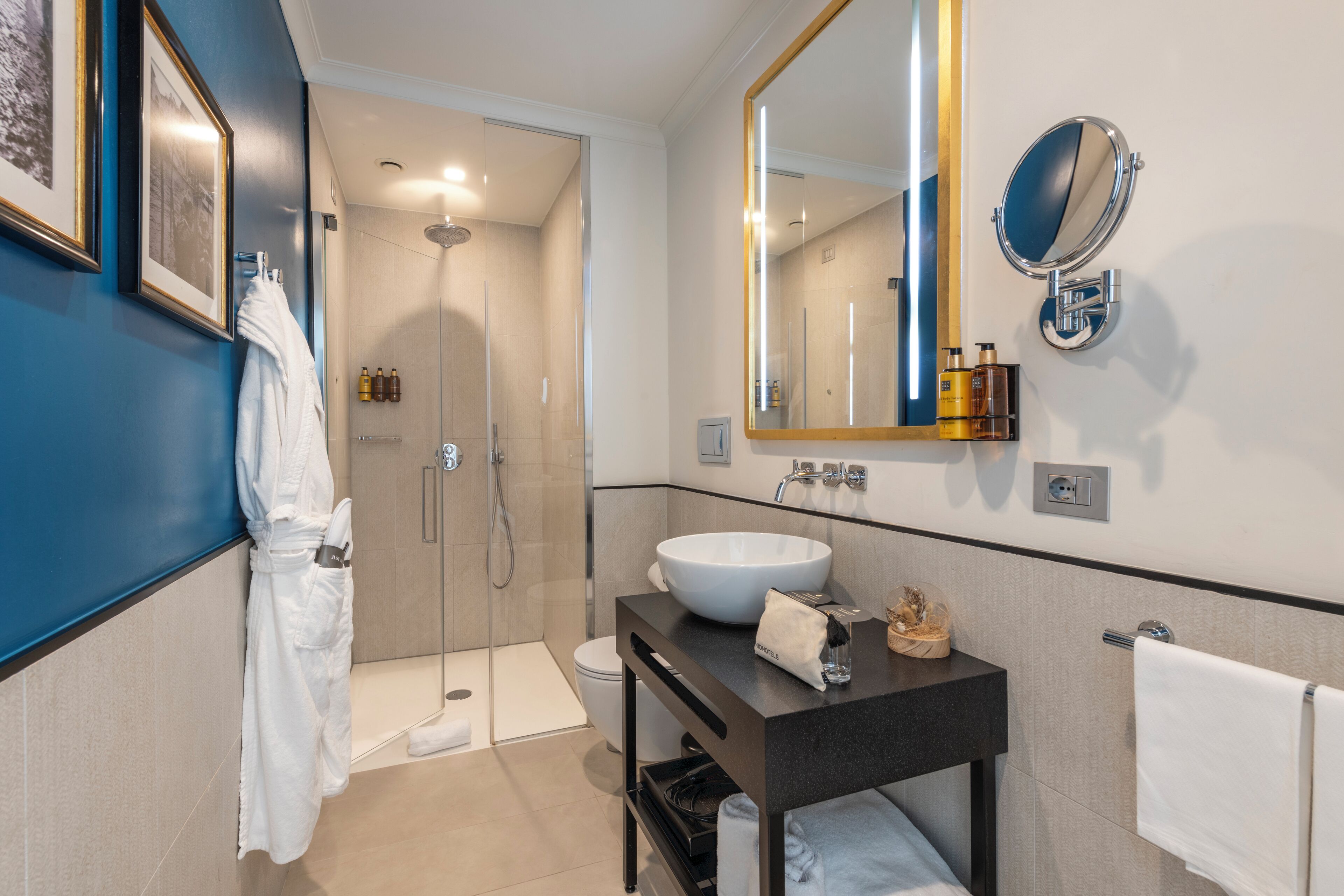 A modern bathroom with a large mirror, a white sink, and a shower area.