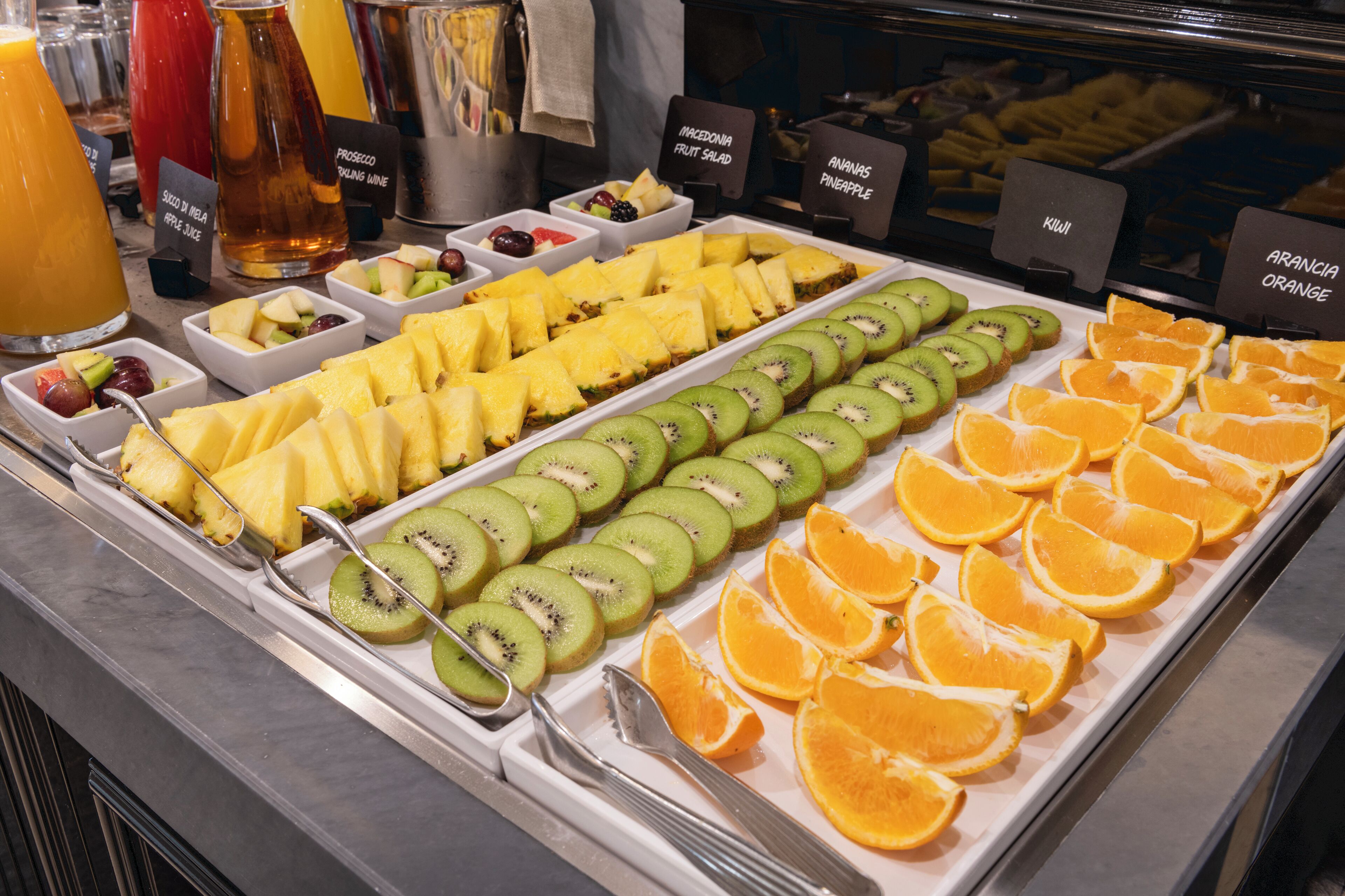 Un ricco buffet della colazione con diversi tipi di frutta e succhi di frutta.