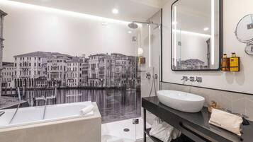 Un baño moderno con una bañera grande, una ducha con cerramiento de vidrio y un espejo amplio.