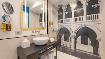 Un baño moderno con un espejo grande, un lavabo blanco y una ducha.