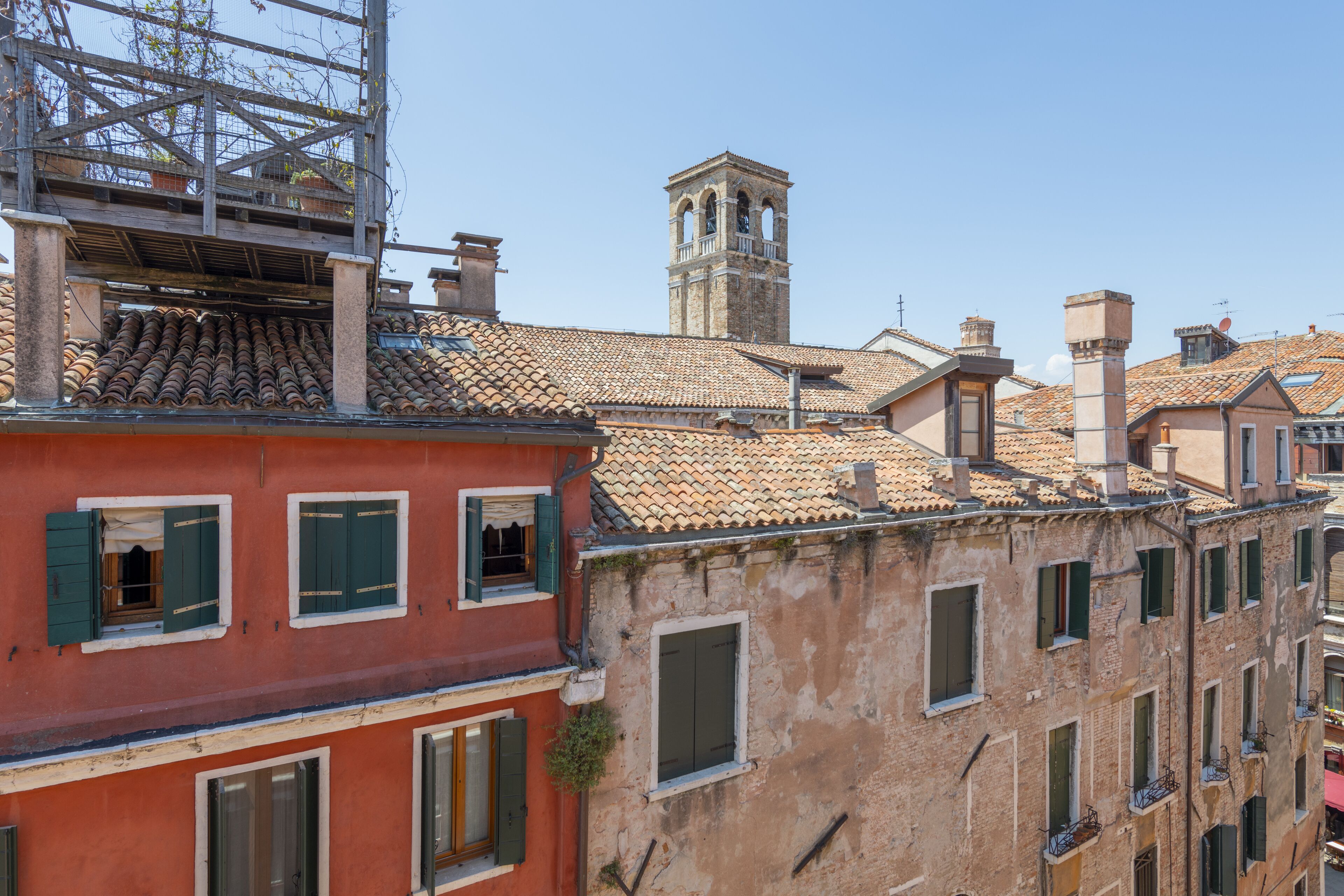 A historic building with a tiled roof, multiple windows, and a bell tower.