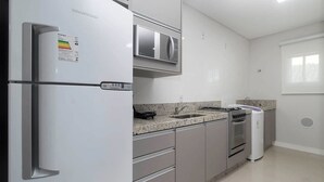 Une cuisine moderne équipée d’un réfrigérateur, d’un four à micro-ondes, d’une cuisinière et d’un four intégrés.