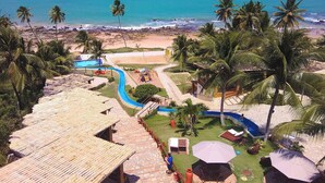 Un resort con piscina, playa y palmeras.