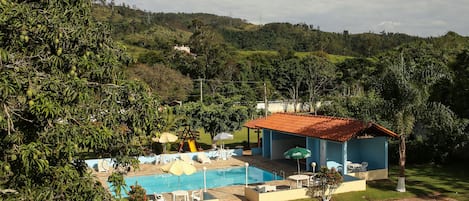 Una piscina al aire libre, sillones reclinables de piscina