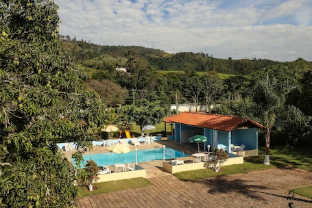 Una piscina al aire libre, sillones reclinables de piscina