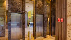 A modern elevator area with marble walls and a polished floor. - Nanu Resort, Arambol (Arambol)