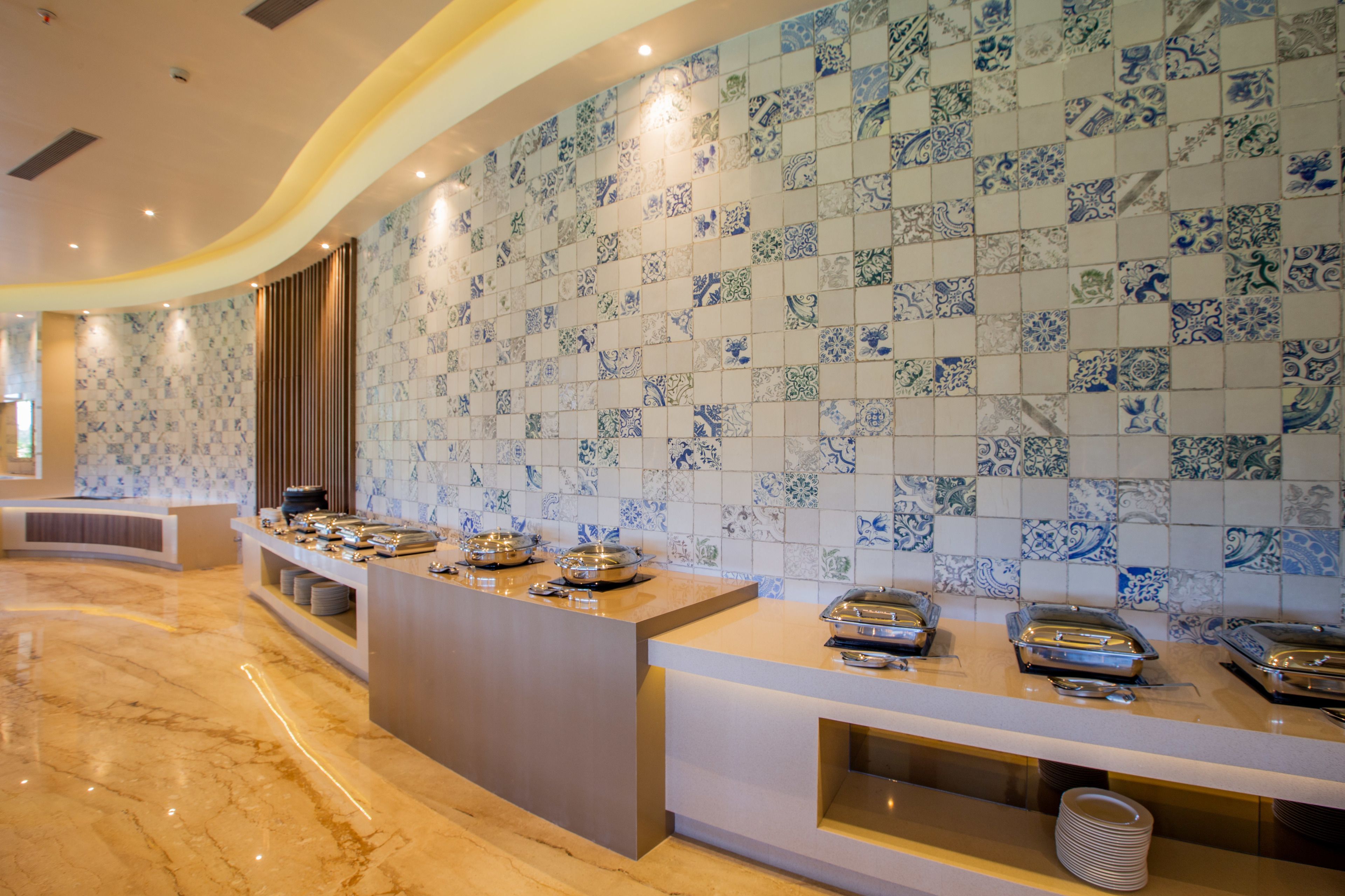 Un área de bufé con piso de mármol y pared de azulejos con diseño azul y blanco.