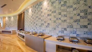 Uma área de buffet com piso de mármore e parede revestida com um padrão azul e branco.