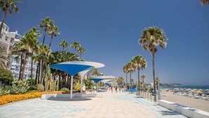A promenade with palm trees, a beach, and a clear sky. - Hotel Mare Estepona (Estepona)