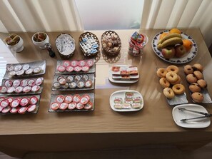A buffet table with various food items including pastries, donuts, and fruit. - Hotel Mare Estepona (Estepona)