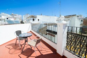 A rooftop terrace with a table and two chairs, a white railing, and a view of white buildings. - Hotel Mare Estepona (Estepona)